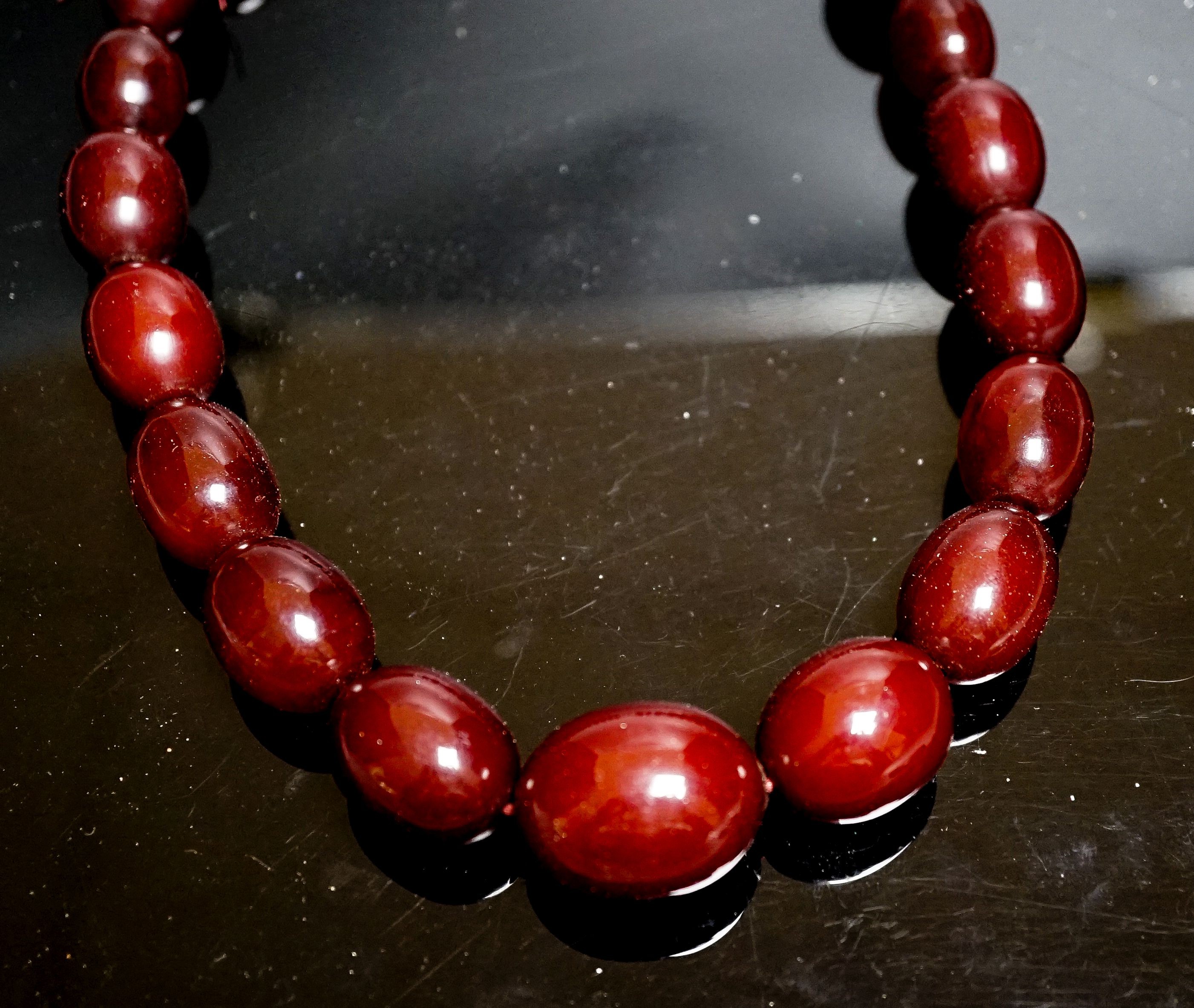 A single strand graduated simulated cherry amber oval bead necklace, 44cm, gross weight 78 grams.